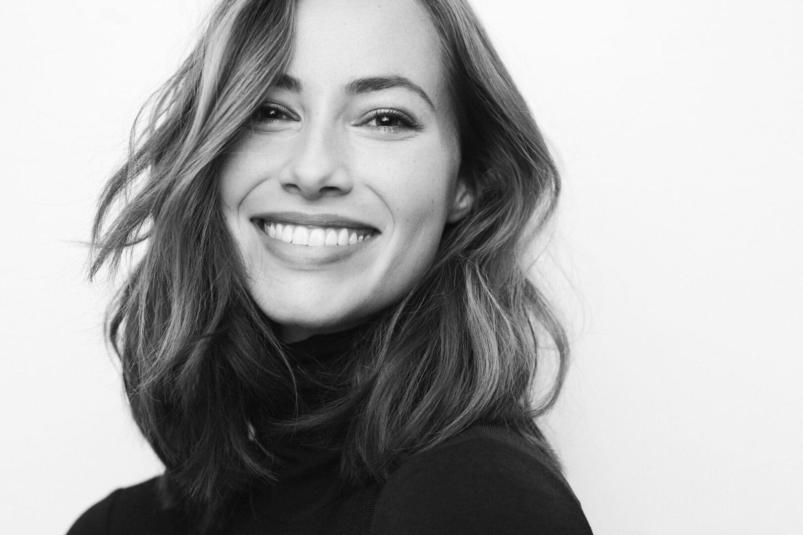 Black and white portrait of young happy woman with a big smile o
